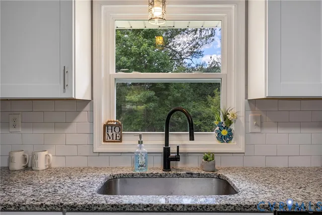 a kitchen with granite countertop a sink and a window