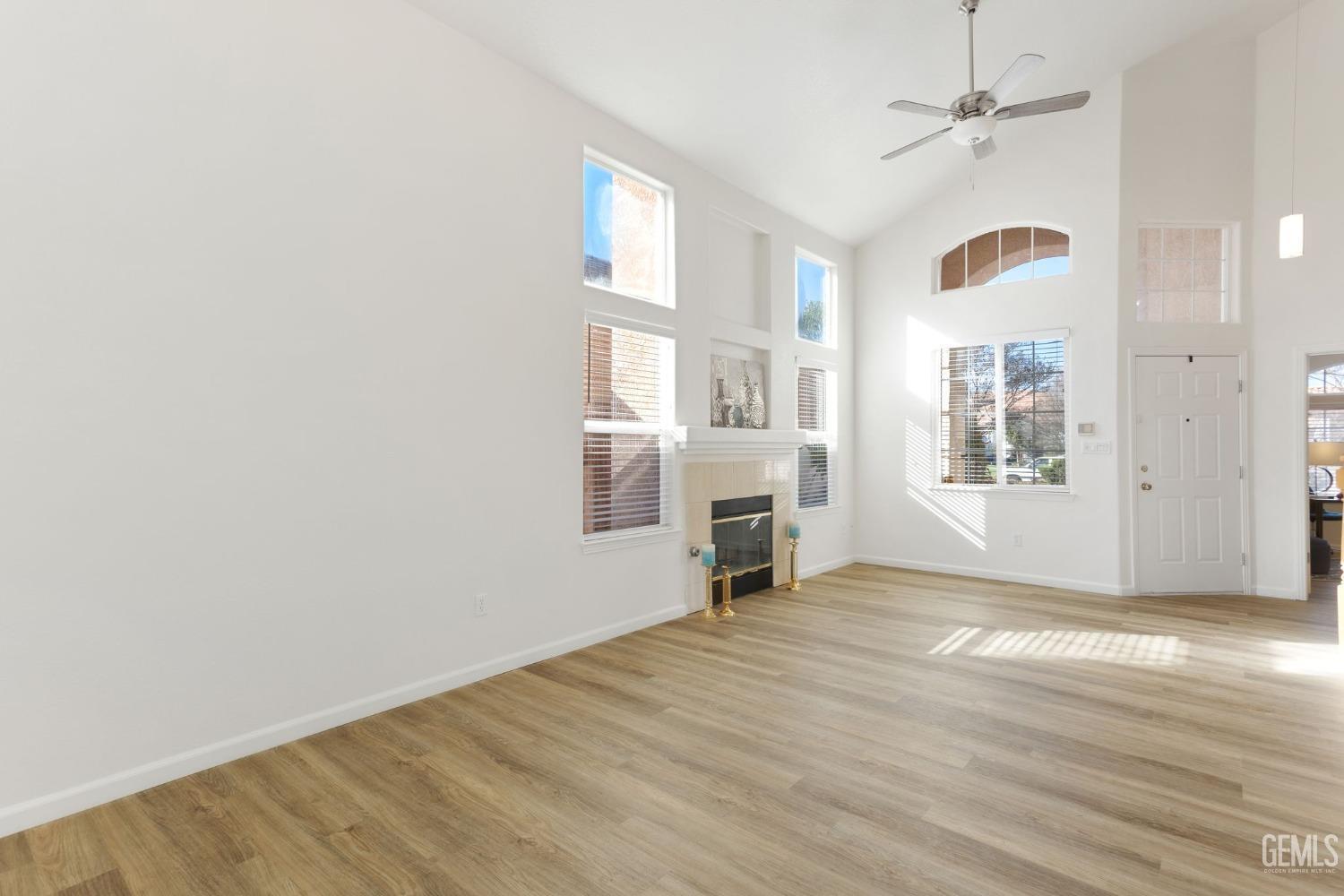 Undisclosed Address Bakersfield, CA 93311 - Photo 11 of 52 a view of a livingroom with wooden floor a ceiling fan and windows