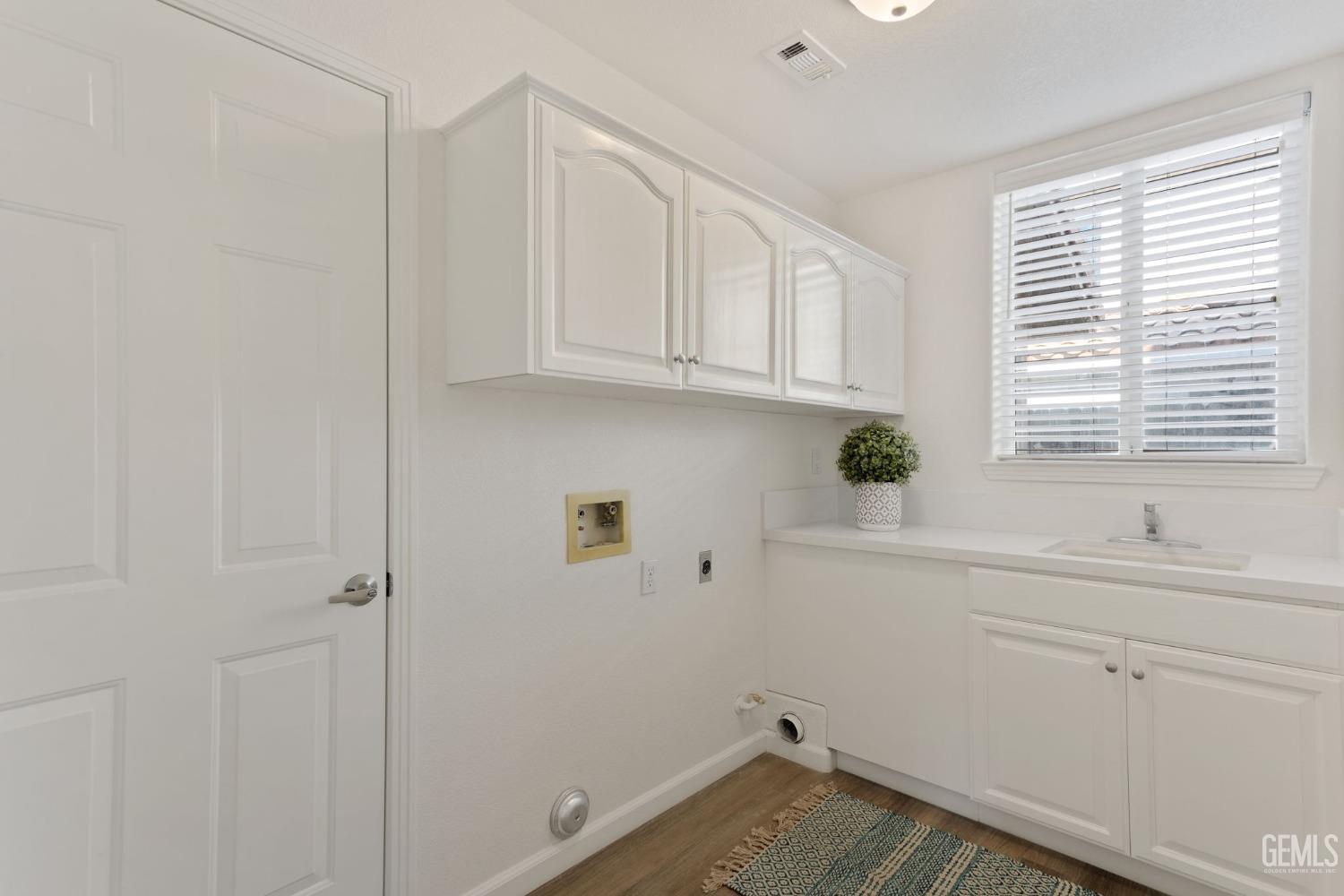 Undisclosed Address Bakersfield, CA 93311 - Photo 23 of 52 a view of a kitchen with white cabinets and a window