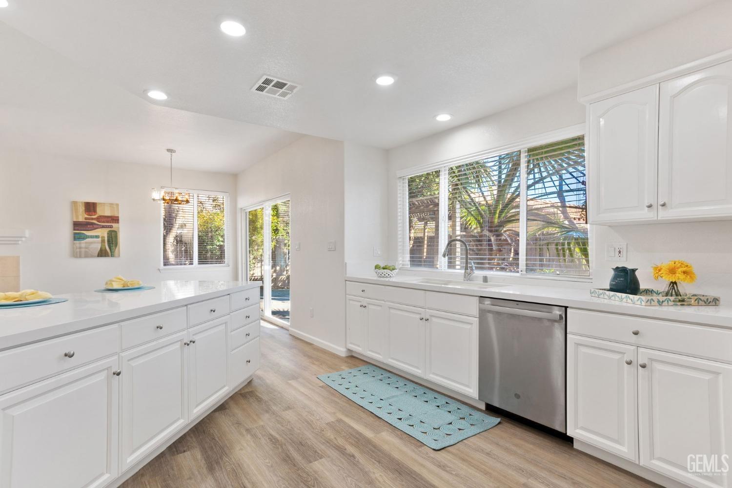 Undisclosed Address Bakersfield, CA 93311 - Photo 29 of 52 a large white kitchen with granite countertop a stove a sink a window and white cabinets