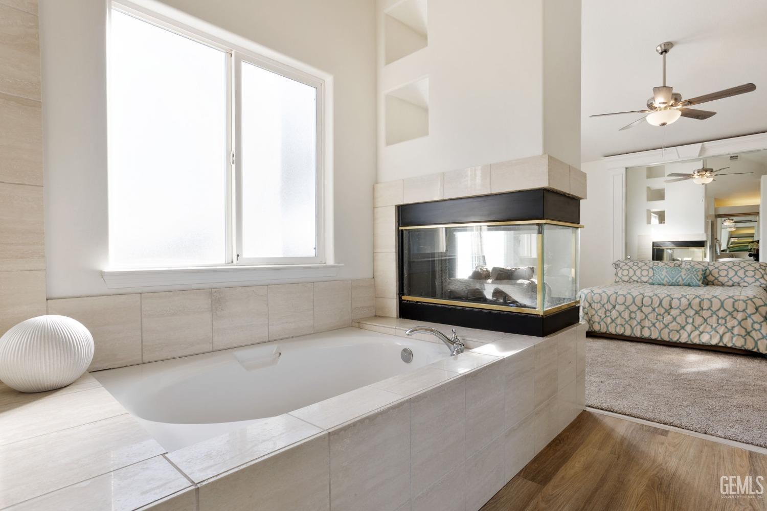 Undisclosed Address Bakersfield, CA 93311 - Photo 40 of 52 a bathroom with a tub a sink and a large mirror