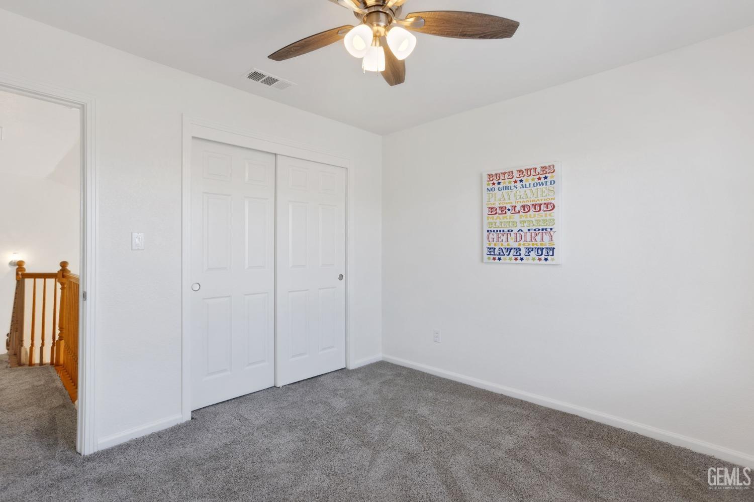 Undisclosed Address Bakersfield, CA 93311 - Photo 43 of 52 an empty room with a chandelier fan