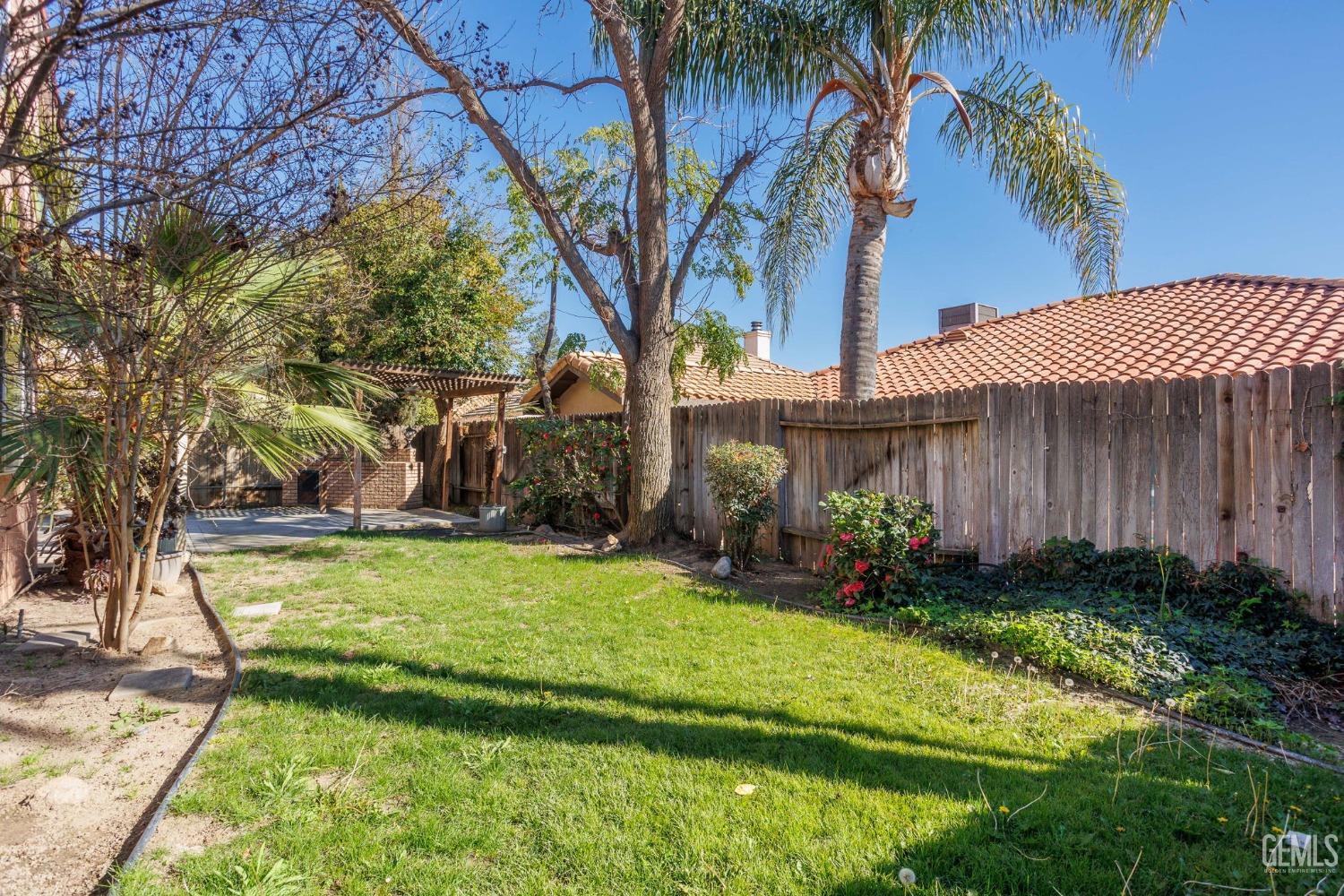 Undisclosed Address Bakersfield, CA 93311 - Photo 49 of 52 a view of a backyard with potted plants and large trees