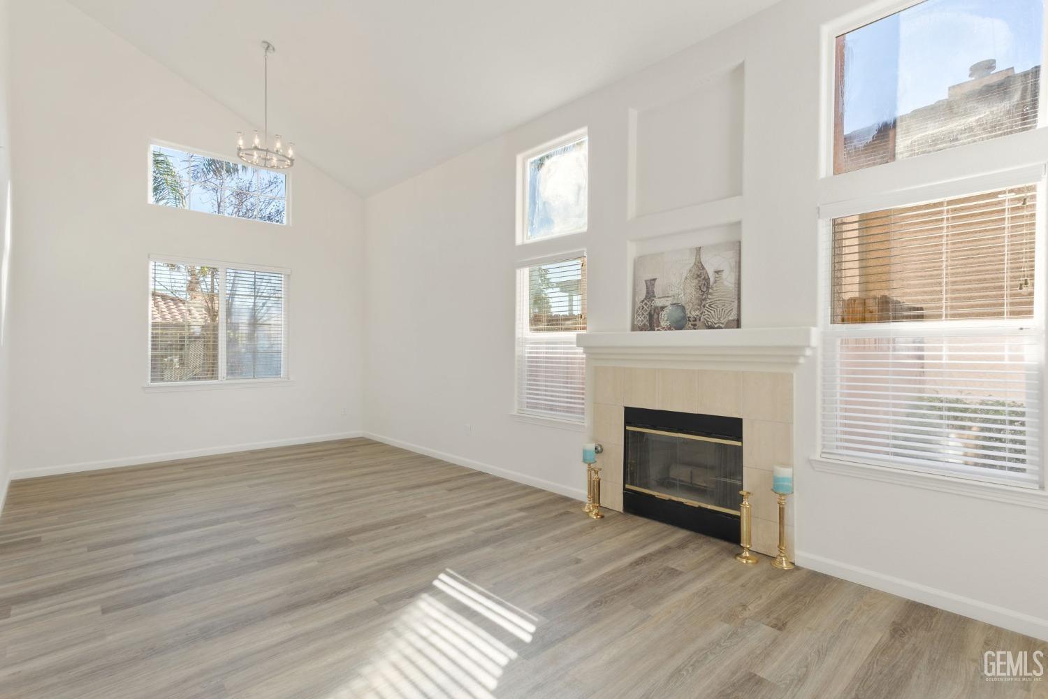 Undisclosed Address Bakersfield, CA 93311 - Photo 8 of 52 an empty room with windows fireplace and cabinet