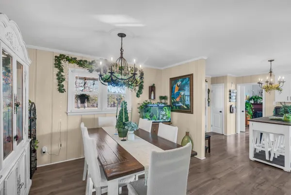 a dining room with furniture a chandelier and wooden floor