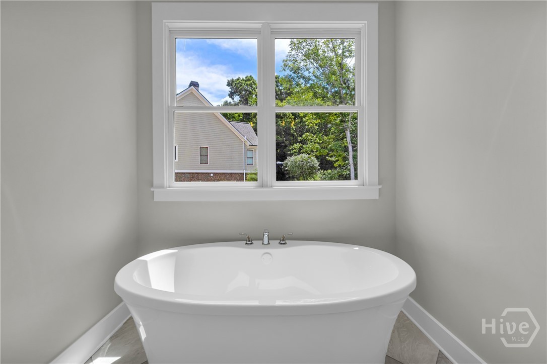 2476 St Martin Way Monroe, GA 30656 - Photo 42 of 75 Freestanding soaking tub with polished chrome fixtures set beneath a double-hung window