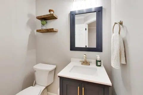 a bathroom with a sink toilet and mirror