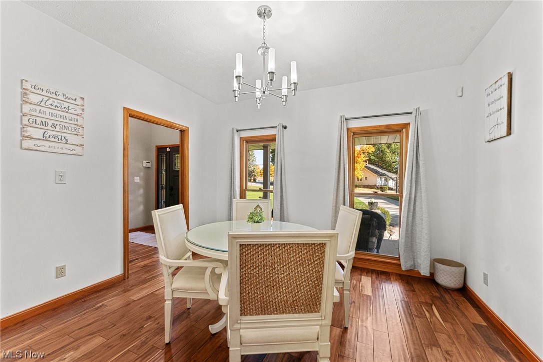 7534 Rice Road Amherst, OH 44001 - Photo 12 of 35 Dining area with dark hardwood / wood-style flooring, an inviting chandelier, and a healthy amount of sunlight