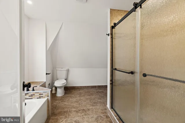 a bathroom with a toilet and a shower