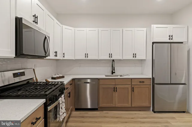 a kitchen with stainless steel appliances white cabinets and a stove top oven