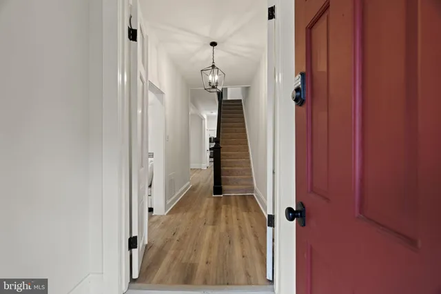 a view of a hallway with wooden floor and staircase