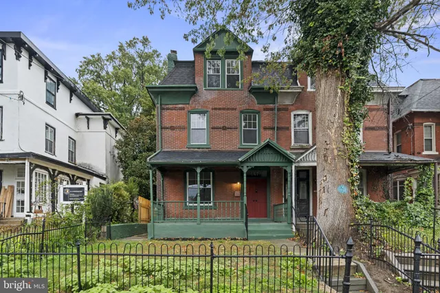 a view of a porch with a floor to ceiling window and potted plants