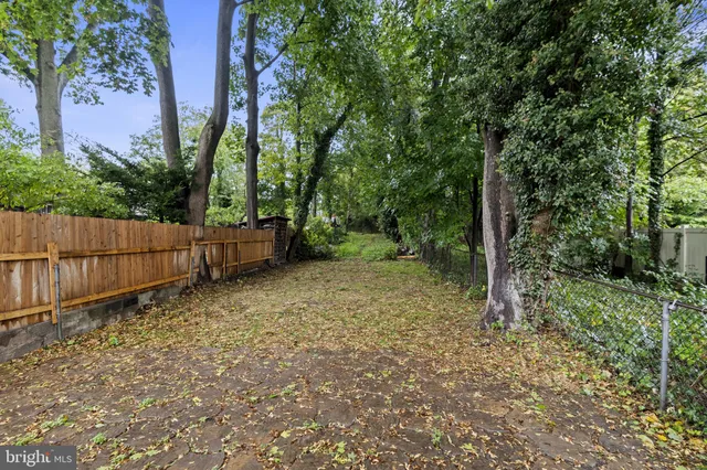a view of a house with a yard and wooden fence