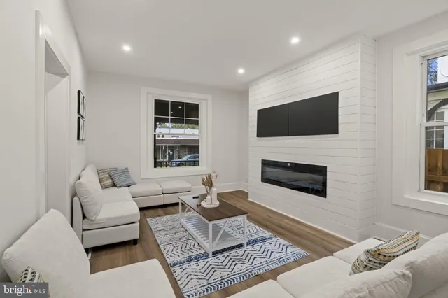 a living room with furniture a flat screen tv and a fireplace