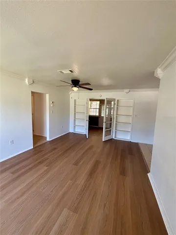 a view of empty room with wooden floor