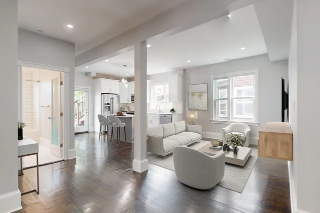 a living room with furniture wooden floor and a large window