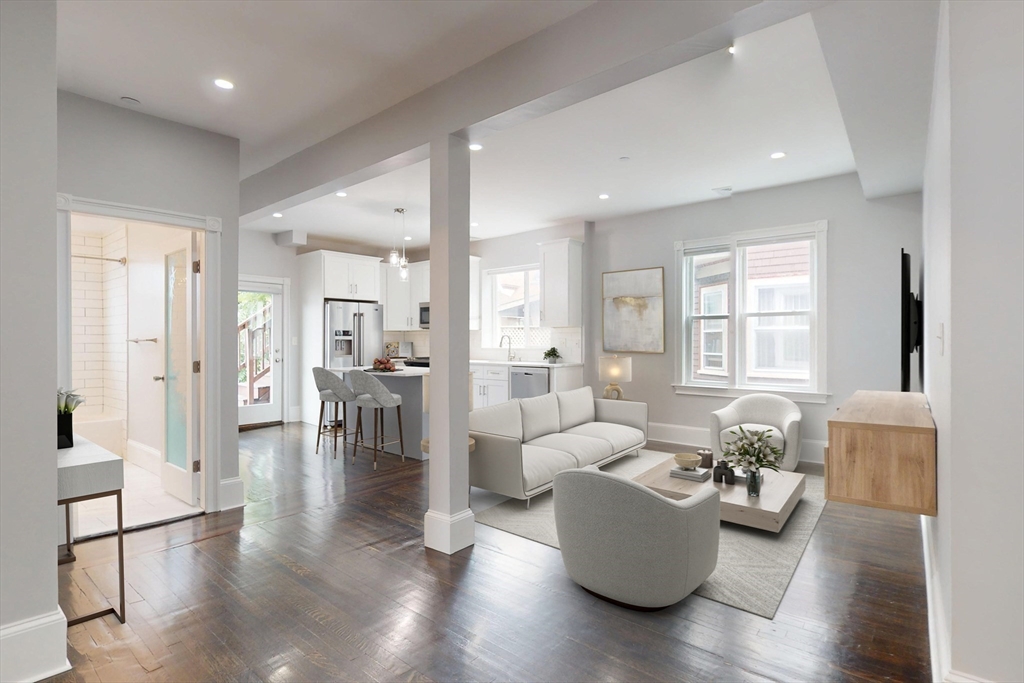 a living room with furniture wooden floor and a large window