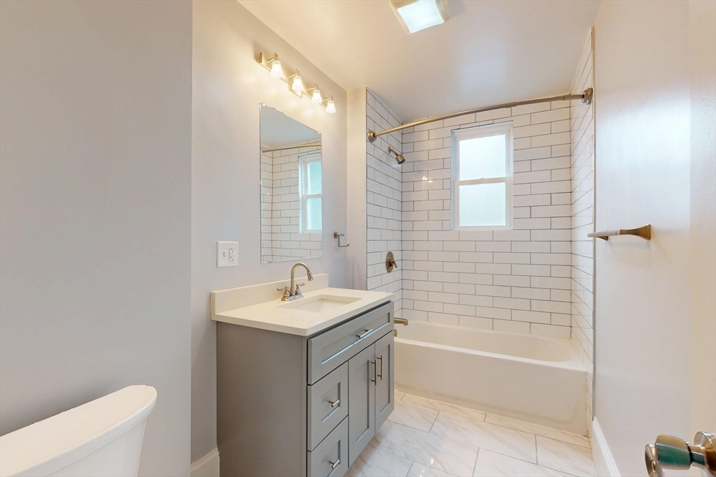61 Charlotte Street, Unit 2 Boston, MA 02121 - Photo 11 of 36 a bathroom with a tub sink and mirror