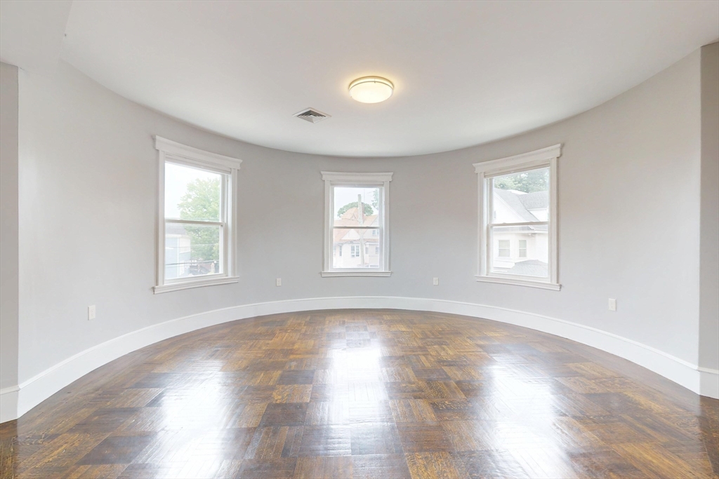 61 Charlotte Street, Unit 2 Boston, MA 02121 - Photo 18 of 36 an empty room with wooden floor and windows