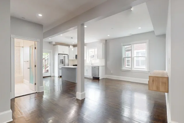 a view of empty room with wooden floor and windows