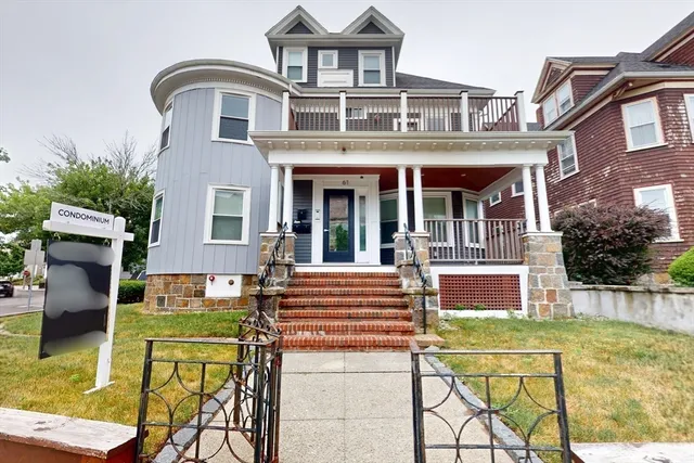 front view of a brick house with a swimming pool