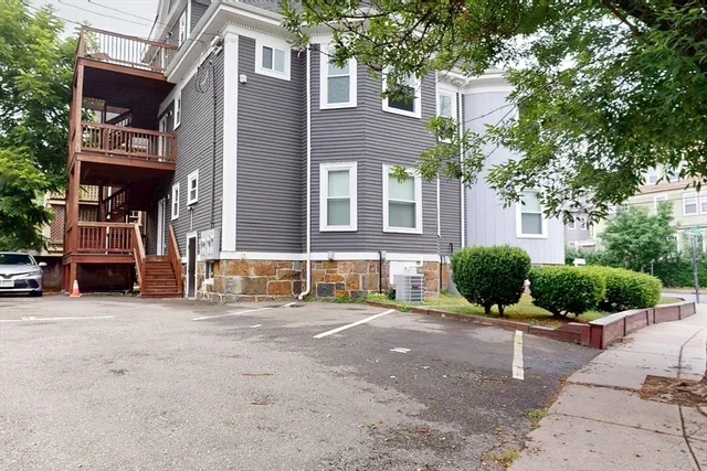 a view of a building with a car park front of house