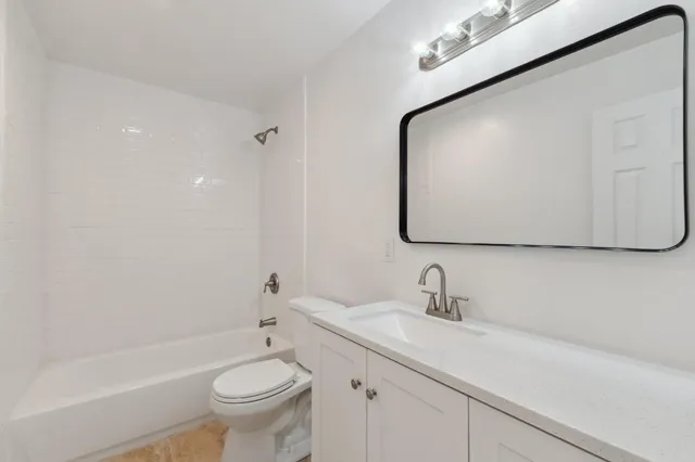 a bathroom with a toilet a sink a mirror and bathtub