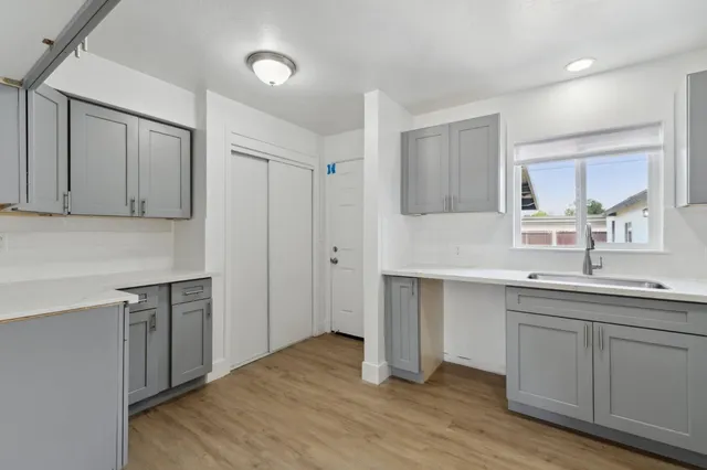 a kitchen with a sink cabinets and wooden floor