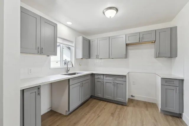 a kitchen with a sink cabinets and wooden floor