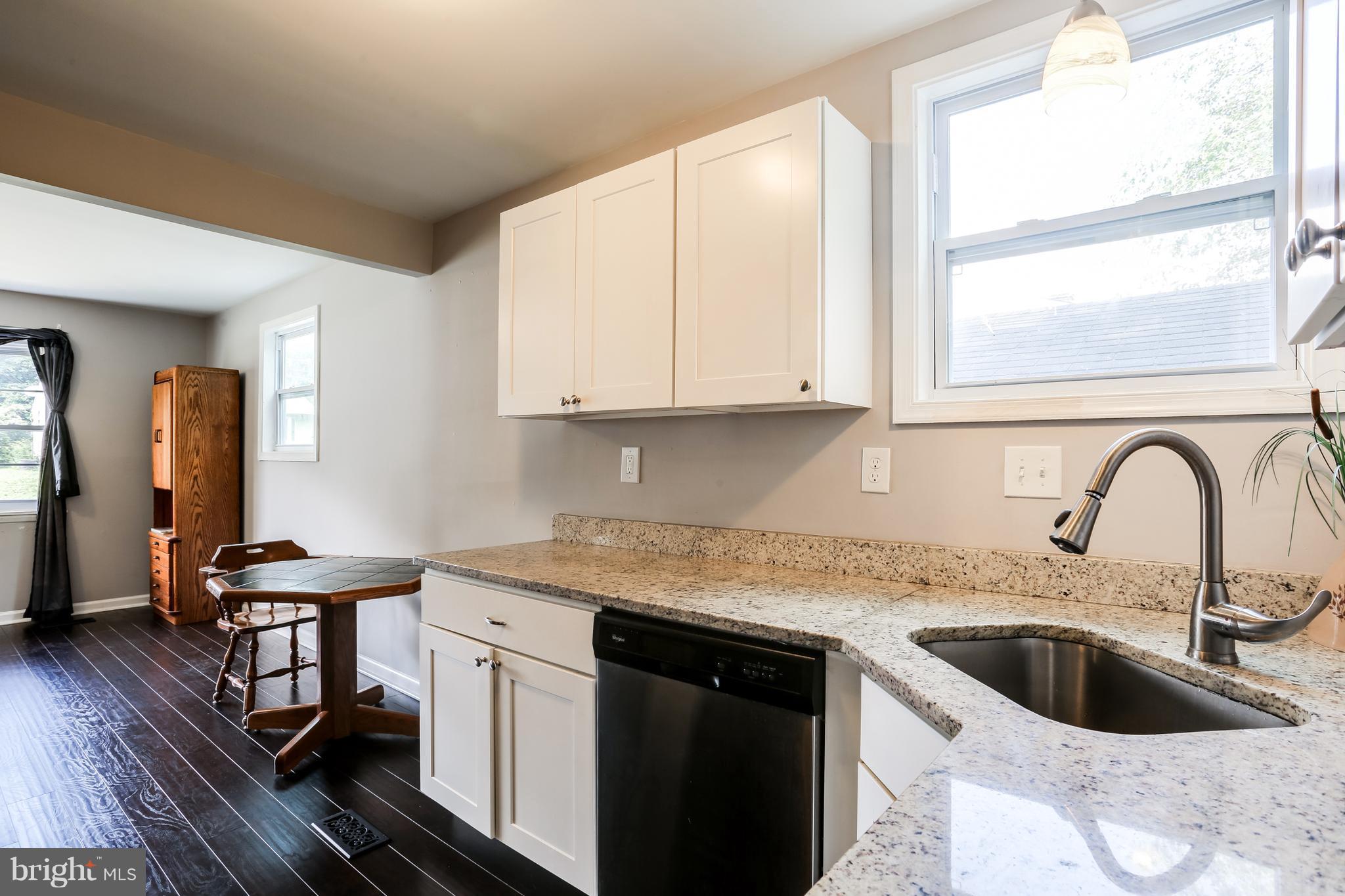 19 Millgate Road Owings Mills, MD 21117 - Photo 11 of 30 a kitchen with stainless steel appliances granite countertop a sink a stove and white cabinets with wooden floor