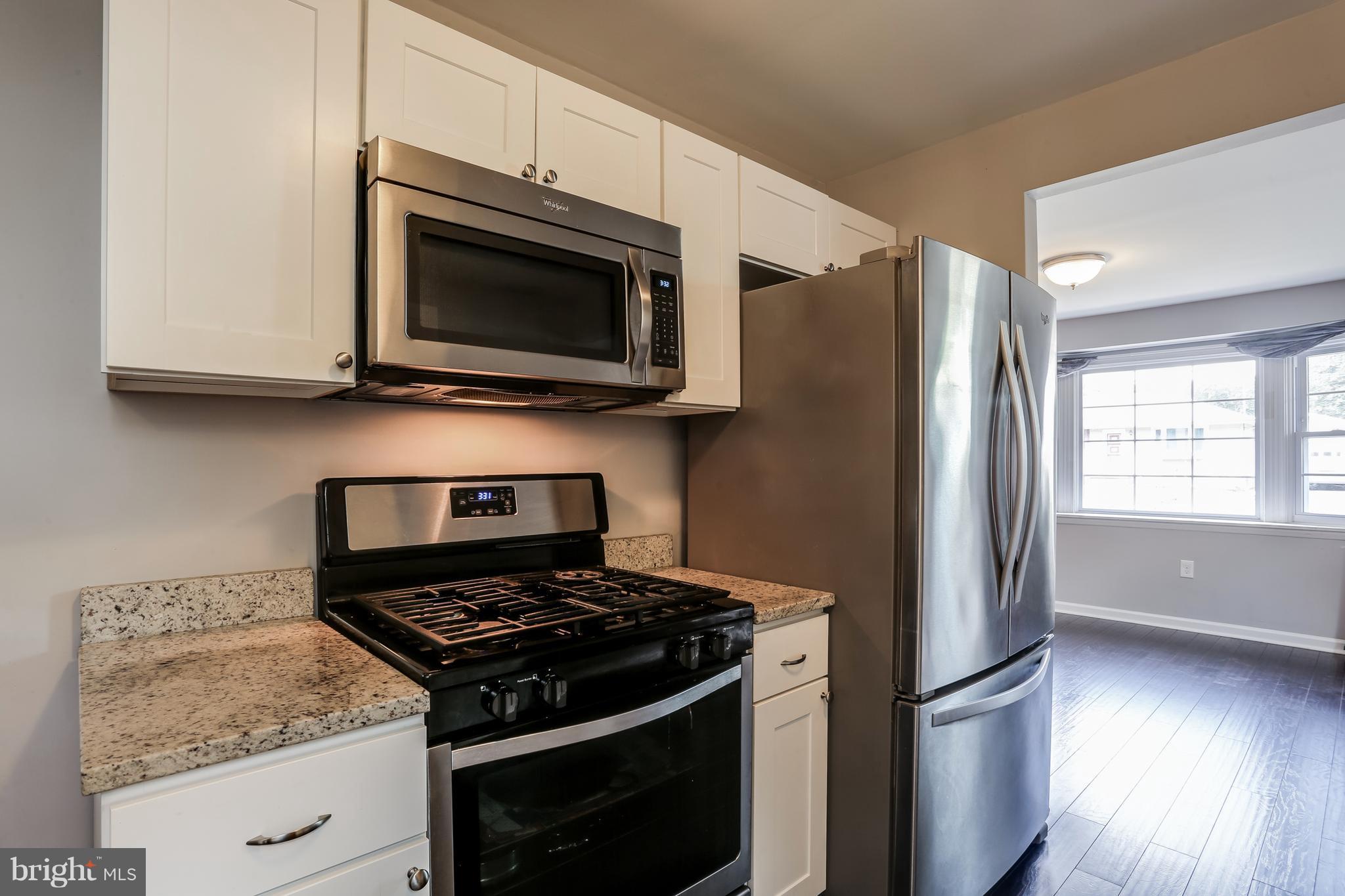 19 Millgate Road Owings Mills, MD 21117 - Photo 12 of 30 a kitchen with stainless steel appliances granite countertop a stove microwave and refrigerator