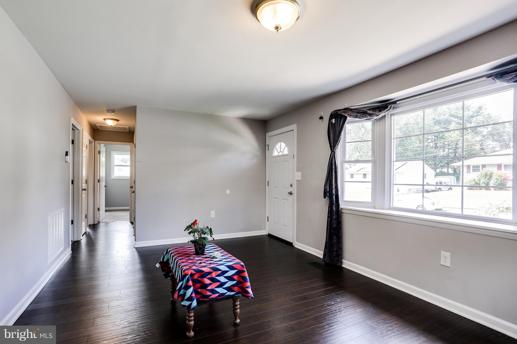 19 Millgate Road Owings Mills, MD 21117 - Photo 3 of 30 a hallway with wooden floor and a chandelier