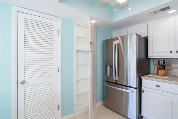a kitchen with white cabinets and white appliances