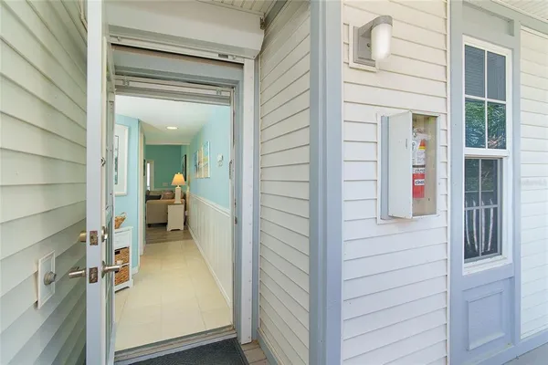 a view of a hallway with a glass door and a bathroom