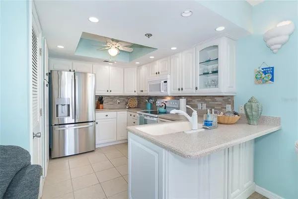 a kitchen with white cabinets and white appliances