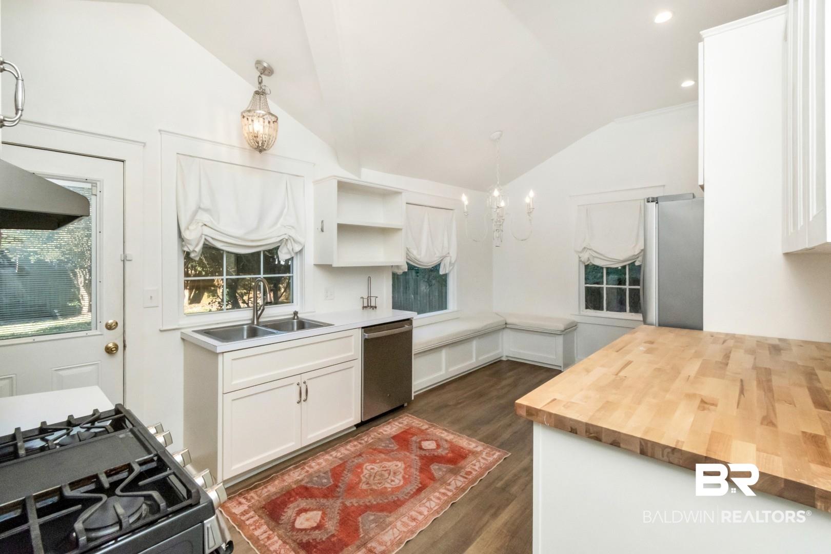 16 Princess Anne Road Mobile, AL 36608 - Photo 8 of 40 Kitchen featuring white cabinetry, hanging light fixtures, butcher block countertops, stainless steel appliances, and a chandelier