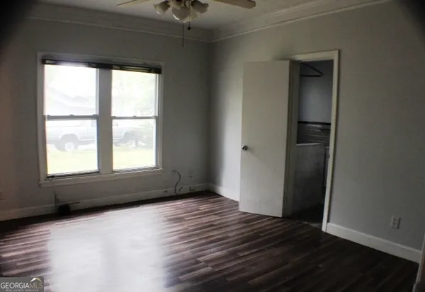 an empty room with wooden floor and windows