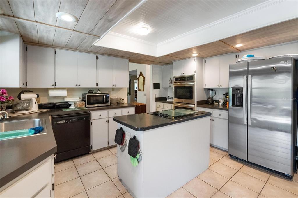 1245 Curlew Road Dunedin, FL 34698 - Photo 11 of 42 a kitchen with a sink a refrigerator and cabinets