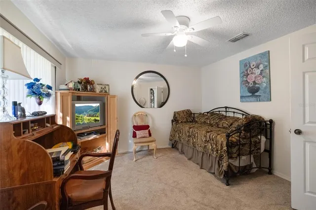 a living room with furniture a clock on wall and a large window