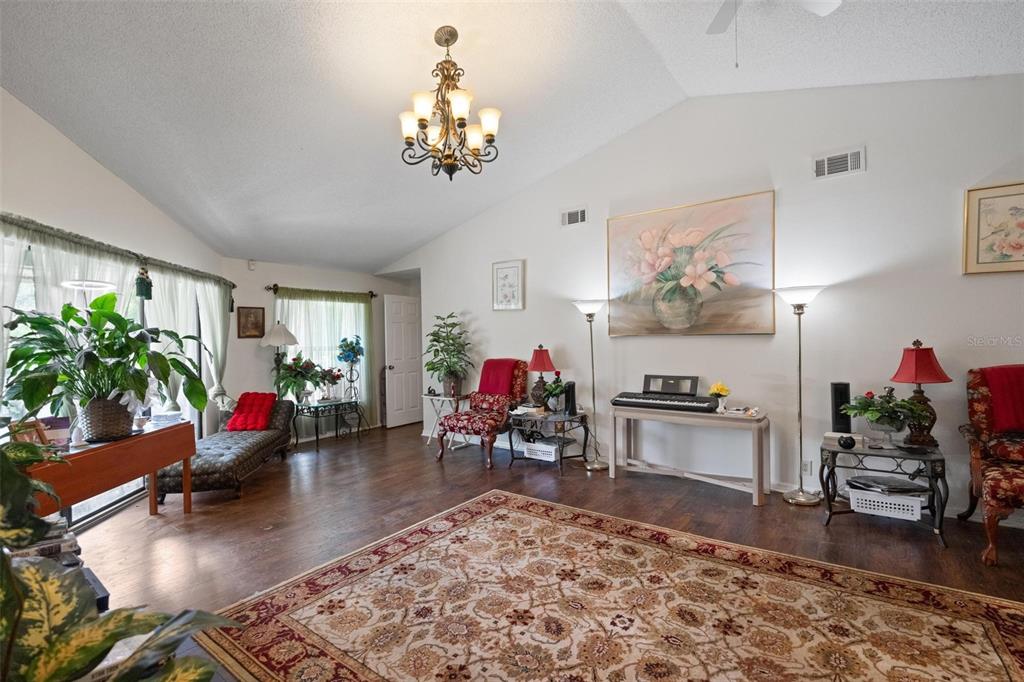 1245 Curlew Road Dunedin, FL 34698 - Photo 6 of 42 a living room with furniture and a chandelier