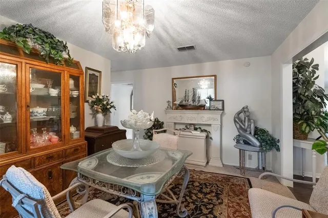 a living room with furniture a chandelier and a dining table