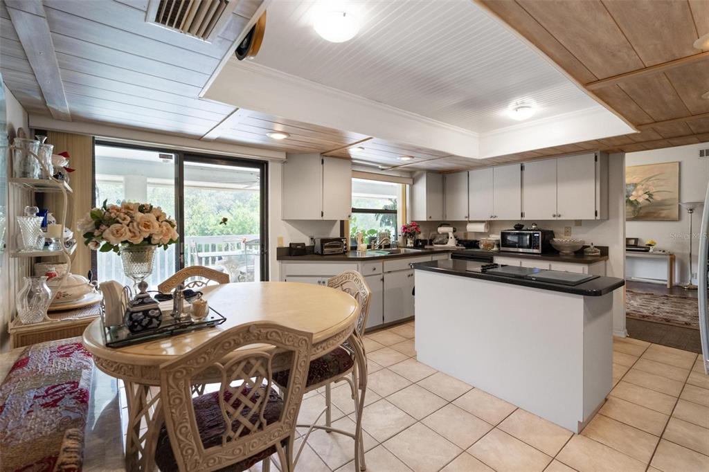 1245 Curlew Road Dunedin, FL 34698 - Photo 10 of 42 a kitchen with kitchen island granite countertop lots of counter top space and refrigerator