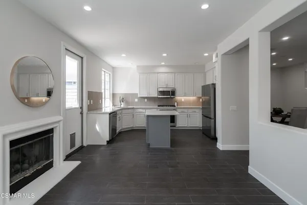 a kitchen with a refrigerator sink and cabinets