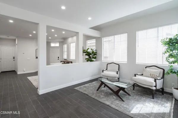 a living room with furniture a window and wooden floor