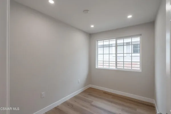 an empty room with wooden floor and a window
