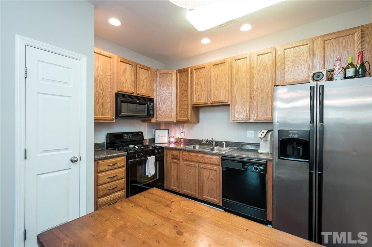 2210 Raven Road, Unit 108 Raleigh, NC 27614 - Photo 11 of 22 a kitchen with stainless steel appliances granite countertop a stove a sink and a refrigerator