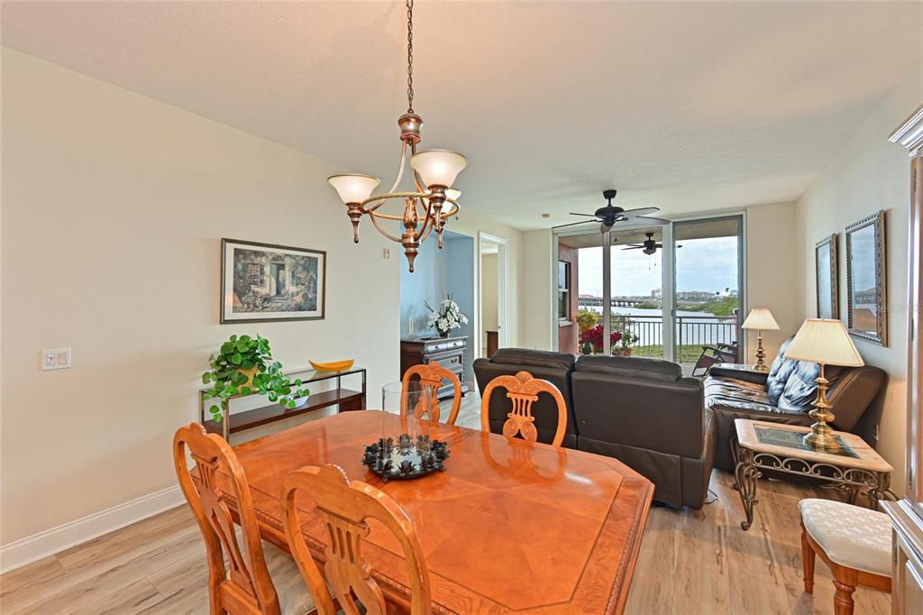 615 Riviera Dunes Way, Unit 107 Palmetto, FL 34221 - Photo 16 of 50 a view of a dining room with furniture a chandelier and wooden floor