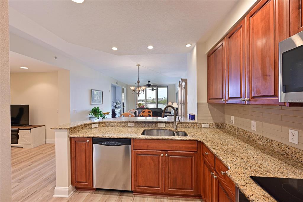 615 Riviera Dunes Way, Unit 107 Palmetto, FL 34221 - Photo 18 of 50 a kitchen with stainless steel appliances granite countertop wooden cabinets a sink and dishwasher