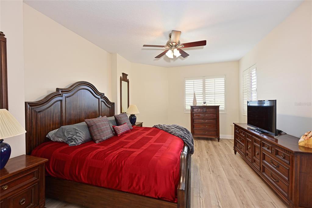 615 Riviera Dunes Way, Unit 107 Palmetto, FL 34221 - Photo 29 of 50 a bedroom with a bed and a flat screen tv