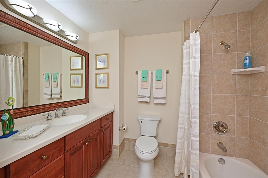 615 Riviera Dunes Way, Unit 107 Palmetto, FL 34221 - Photo 37 of 50 a bathroom with a granite countertop sink toilet and shower